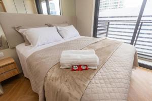 ein Bett mit Handtüchern und einer Fliege drauf in der Unterkunft Studio no All Batel com Cama Articulada - BAT1805 in Curitiba