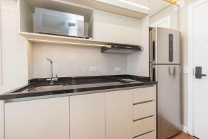 eine Küche mit Spüle und Kühlschrank in der Unterkunft Studio no All Batel com Cama Articulada - BAT1805 in Curitiba + 74 Fotos