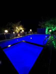 a swimming pool with blue lighting at night at Sai Leela Bungalow - Villa with Private Pool in Mahabaleshwar