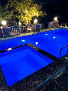 a blue swimming pool at night at Sai Leela Bungalow - Villa with Private Pool in Mahabaleshwar