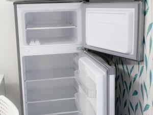 an empty refrigerator with its door open in a kitchen at Stile CAPRI Studio cu terasă ALFA Saturn in Saturn