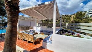 a pergola on a patio with a couch and a table at Vila Sitges, big house with pool in Sitges