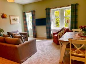 a living room with a couch and a table at Clashmore House Garden Cottage Dornoch in Dornoch
