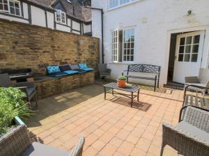 un patio con un banco y una mesa en The Maltster's House, en Ludlow
