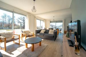 a living room with a couch and a tv at La Maison les Quatre Saisons - Therme - Ski in Saint-Martin-d'Uriage