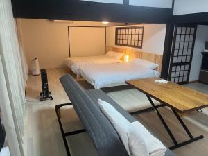 a room with two beds and a wooden table at 甘口派room in Obanazawa