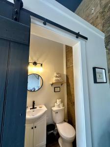 a bathroom with a toilet and a sink at The Stonehouse Makers' Maisonette in Pictou