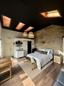 a bedroom with a bed and a stone wall at The Stonehouse Makers' Maisonette in Pictou