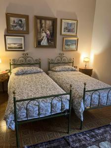 two beds in a bedroom with pictures on the wall at Borgo Caprari in Albinea