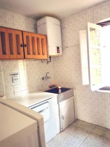 a kitchen with brown cabinets and a white sink at Apartamento MIZA in Ponferrada +9 photos
