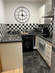 a kitchen with a sink and a clock on the wall at 2 bed apartment Liverpool city centre in Liverpool