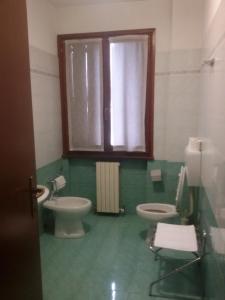 ペーザロにあるHotel Fieraのバスルーム(トイレ2つ、窓付)
