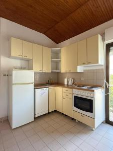 クレックにあるBlue Lagoon Studio Apartmentsの木製の天井、白い家電製品付きのキッチン