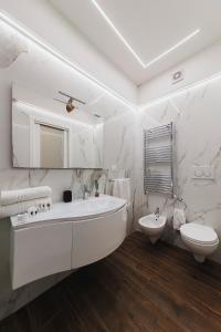 une salle de bain blanche avec un lavabo, une baignoire et des toilettes dans l'établissement Cuore D'aMare B&B, à Bari