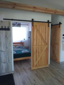 a bedroom with a bed and a sliding barn door at AdMi - domek całoroczny in Krasnobród