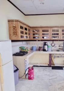 una cocina con armarios de madera y un aparato rosa en Kos Menteng Jakpus, en Yakarta