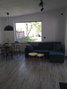a living room with a green couch and a table at AdMi - domek całoroczny in Krasnobród