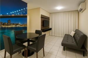 a dining room with a table and chairs and a view of a bridge at Apartamentos Verano in Natal