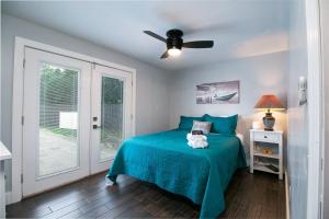 a bedroom with a blue bed and a ceiling fan at The Oasis with New Salt Pool Close to Everything in Gainesville +56 photos