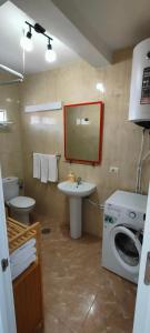 a bathroom with a washing machine and a sink at Alojamiento céntrico Ribeira con parking sin ascensor in Ribeira
