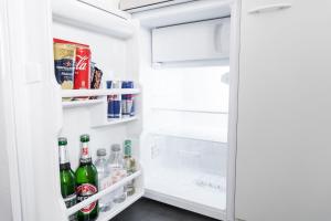 ein offener Kühlschrank mit Getränken in der Tür in der Unterkunft SchaeBu! 2 Apartment stilvoll am Altmarkt in Cottbus