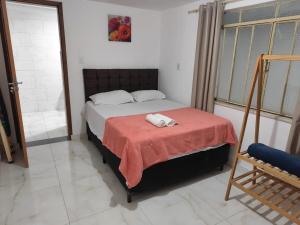 Un dormitorio con una cama con una manta roja. en Kitnet comfort, en Vitória da Conquista