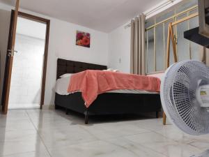 Un dormitorio con una cama y un ventilador. en Kitnet comfort, en Vitória da Conquista 9 fotos más