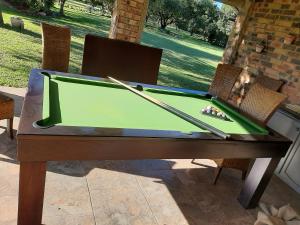 a pool table with cue sticks on top of it at Mountains and More in Hekpoort