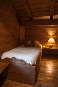 un letto in una baita con una lampada sopra di Les Greniers du Mont Blanc a Passy Altre 7 foto
