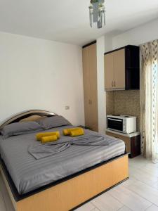 a bedroom with a large bed with yellow pillows on it at Michal's Apartment in Sarandë