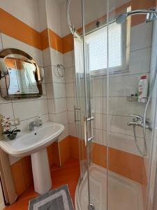 a bathroom with a sink and a glass shower at Michal's Apartment in Sarandë