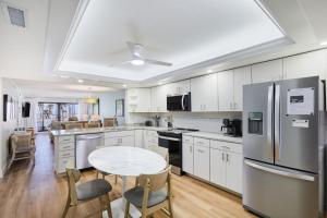 a kitchen with white cabinets and a table and chairs at Pointe Santo C6 - Upgraded Walk Out Residence at Pointe Santo in Sanibel