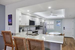 a kitchen with a large marble counter top and chairs at Pointe Santo C6 - Upgraded Walk Out Residence at Pointe Santo in Sanibel