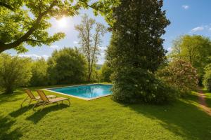 a swimming pool in a yard with two chairs at Dandelion Como Suites & Park in Villa Guardia