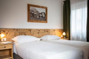 Postel nebo postele na pokoji v ubytování Hotel Panda Cortina- ricarica auto elettriche