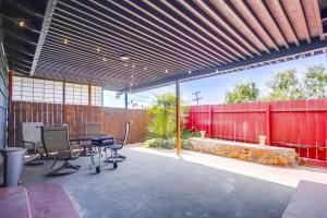 un patio con sillas y una valla roja en Entire Private 3-Bedroom Home w Gated Yard, 100 inch TV, 1 Gbps WiFi, Available Now, en San Diego