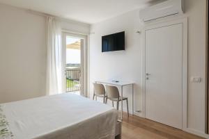 a bedroom with a bed and a table and chairs at LAGOBALDO Apartments - Regarda Travel in Colà di Lazise