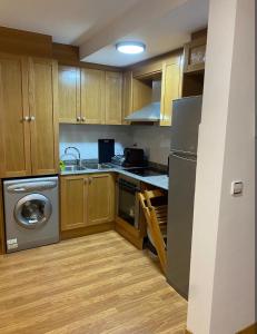 a kitchen with wooden cabinets and a stainless steel appliance at La casina in Mora de Rubielos +3 photos