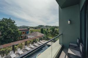 ナイヤンビーチにあるSugar Marina Hotel -AVIATOR- Phuket Airportのバルコニー(椅子付)、建物内のスイミングプール