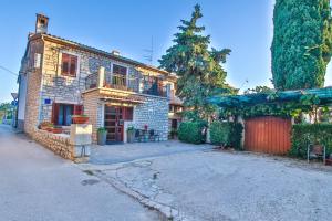 an old brick house with a balcony and a driveway at Mikelic Stara Barbariga in Barbariga