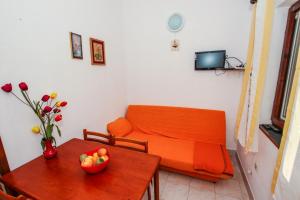 a living room with a couch and a table with a bowl of fruit at Mikelic Stara Barbariga in Barbariga