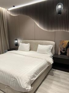 a bedroom with a large bed with white sheets at شقق راحتي جازان للشقق المخدومة in Jazan +41 photos
