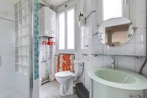 a bathroom with a toilet and a sink and a tub at Comfort and tranquility near the Canal de l Ourcq in Paris
