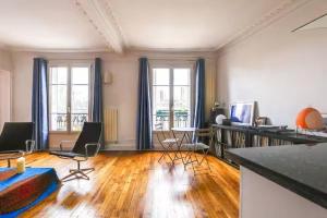 a large living room with wooden floors and windows at Comfort and tranquility near the Canal de l Ourcq in Paris