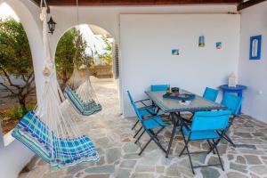 a patio with blue chairs and a table at Villa Rallou in Ierápetra