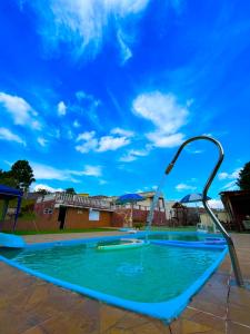 a swimming pool with a water fountain at Chácara Refúgio do Vinho in São Roque