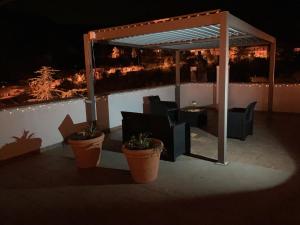 a gazebo with chairs and a table on a patio at night at Casa San Rocco in Guardavalle