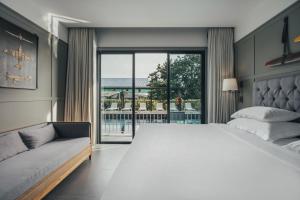 ナイヤンビーチにあるSugar Marina Hotel -AVIATOR- Phuket Airportの大きなベッドとソファのある寝室 +37枚の写真
