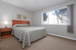 Un dormitorio blanco con una cama y una ventana. en Paradise Canyon Golf Resort - Luxury Condo M401, en Lethbridge