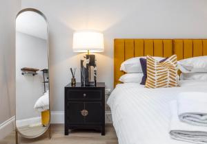 ein Schlafzimmer mit einem Bett mit Spiegel und Lampe in der Unterkunft Arlington Apartments - City Centre Luxury Apartments in Glasgow + 12 Fotos